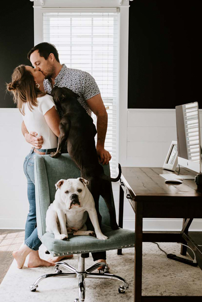 married couple kissing with dogs nearby