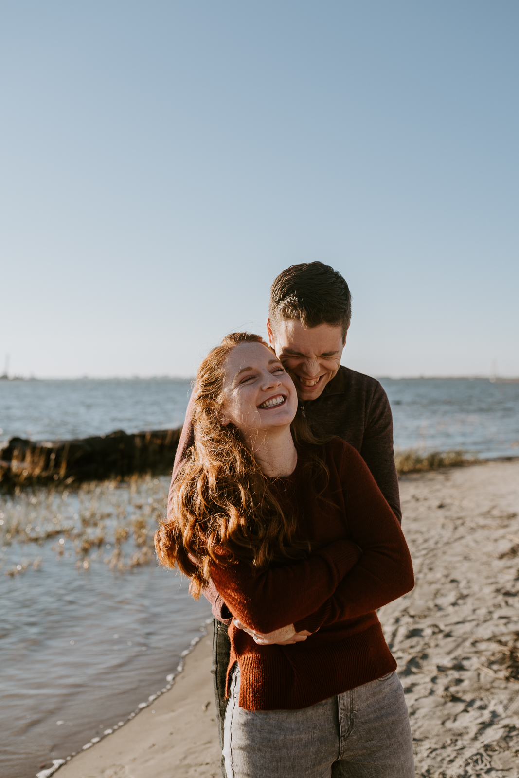 couple holding each other on the beach and smiling